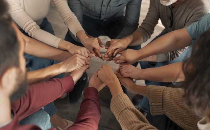 Group of people holding hands together in a circle