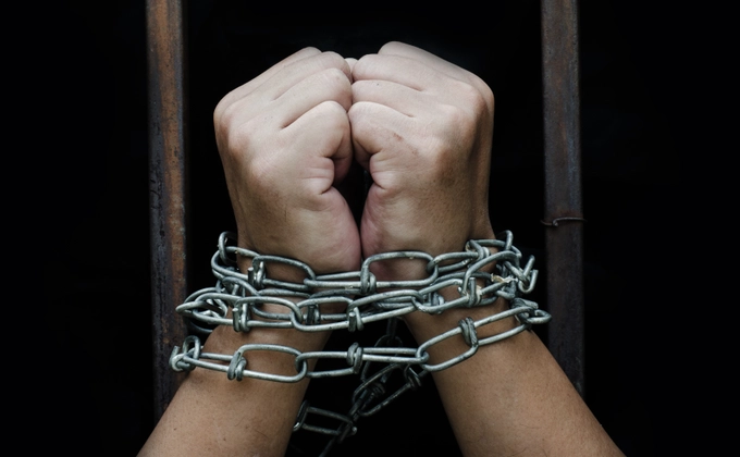 The hands of an person tied in chains