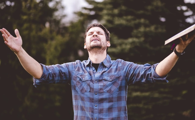 man with hands lifted up