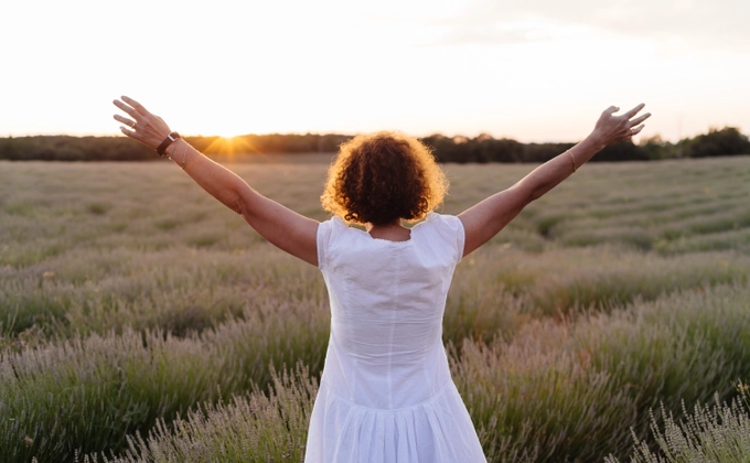 woman with hands up to sky