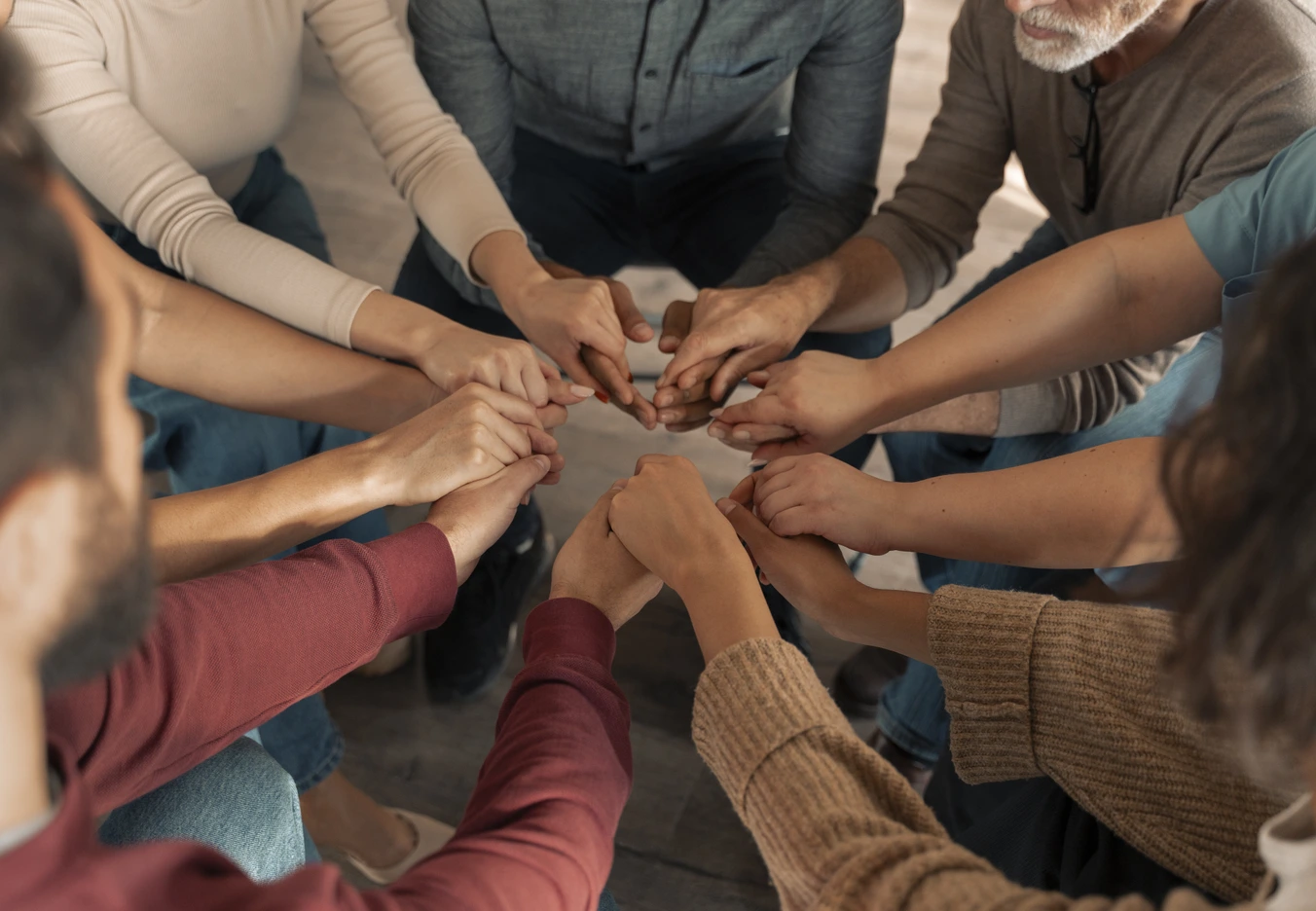 Group of people holding hands together in a circle