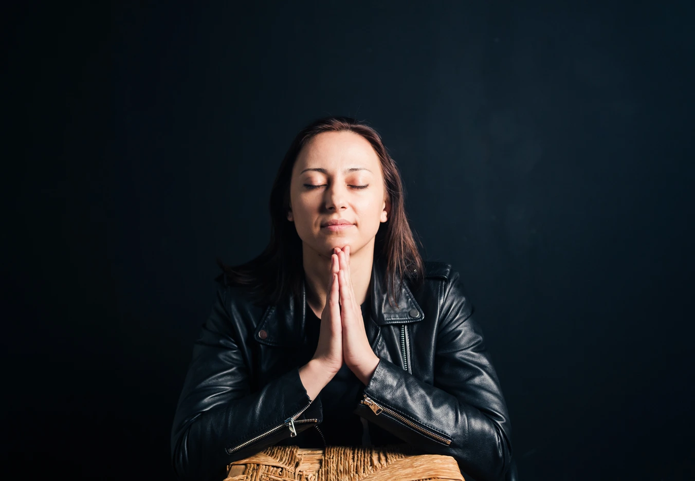 A woman praying fervently with a solemn face