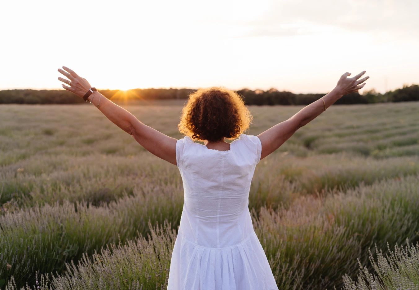 woman with hands up to sky